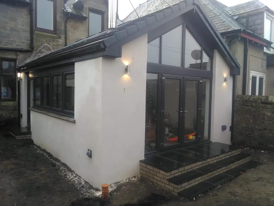 The extension consists of anthracite grey windows and doors, glass gable front, vaulted ceiling with 4 velux windows and spotlights. We finished off with a smooth white render on the outside. Crosssgates